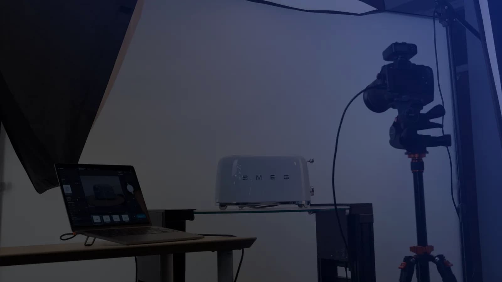 Produktfotografering med tethering - en laptop med tagningsmjukvara bredvid en kamera på stativ och en produkt på en glashylla
