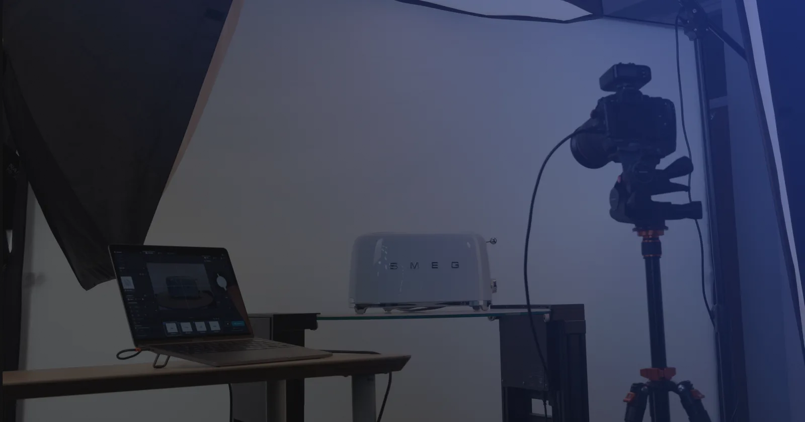 Produktfotografering med tethering - en laptop med tagningsmjukvara bredvid en kamera på stativ och en produkt på en glashylla