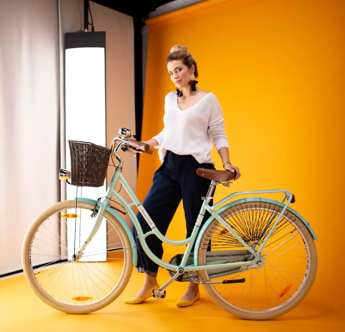 Modell som står bredvid en cykel i Orbitvus studio för fotografering med livemodeller