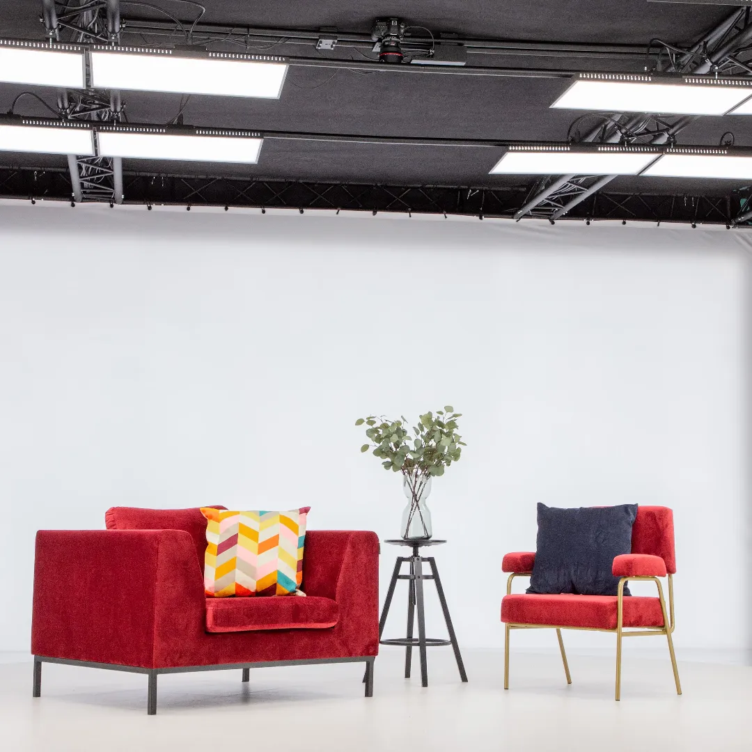 Moderna röda fåtöljer och sidobord i en professionell fotostudio