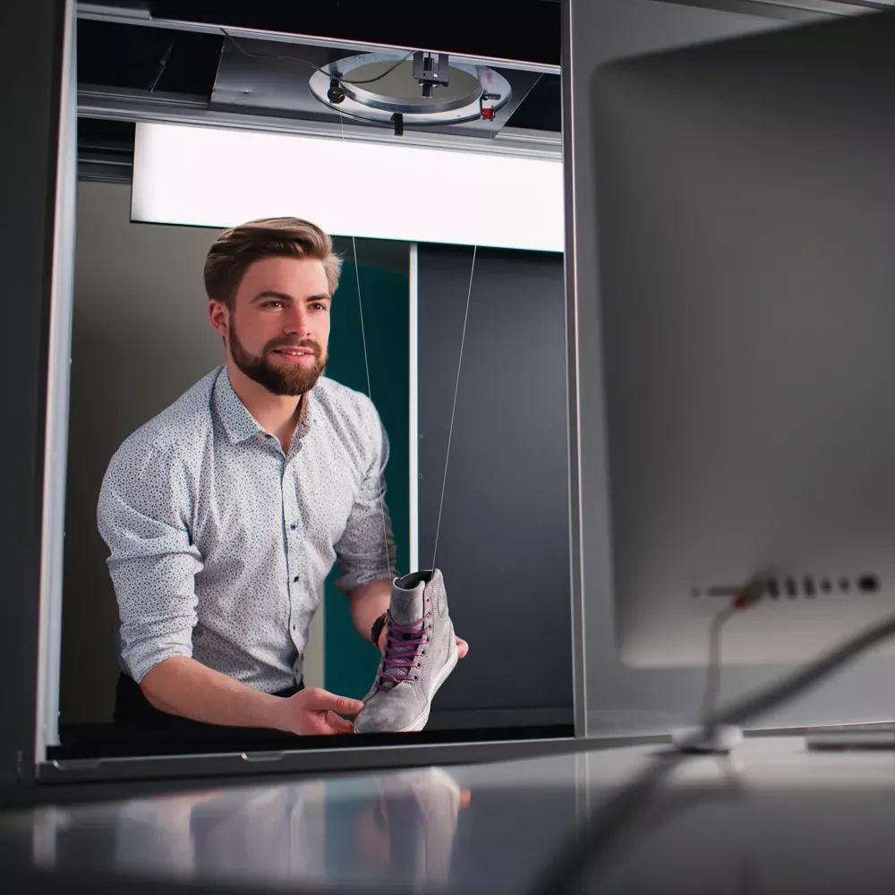 Man som förbereder en produkt för professionell skofotografering